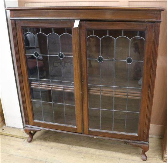 An early 20th century walnut bookcase with leaded glass doors W.121cm